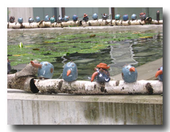 Vogelskulpuren auf dem Rand des Brunnen im Innenhof des Finanzamts